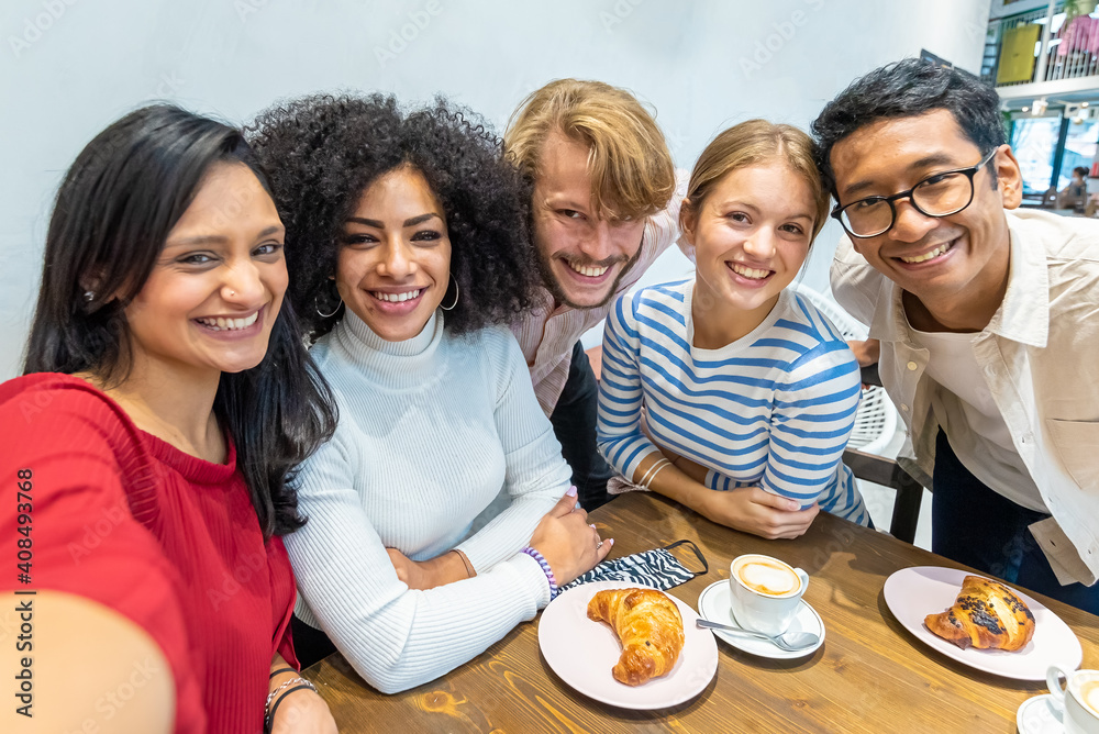 smiling friends take a selfie during breakfast, multi-ethnic university Erasmus group in a moment of rest and coffee takes a souvenir photo, concept of resumption of sociality after the epidemic,