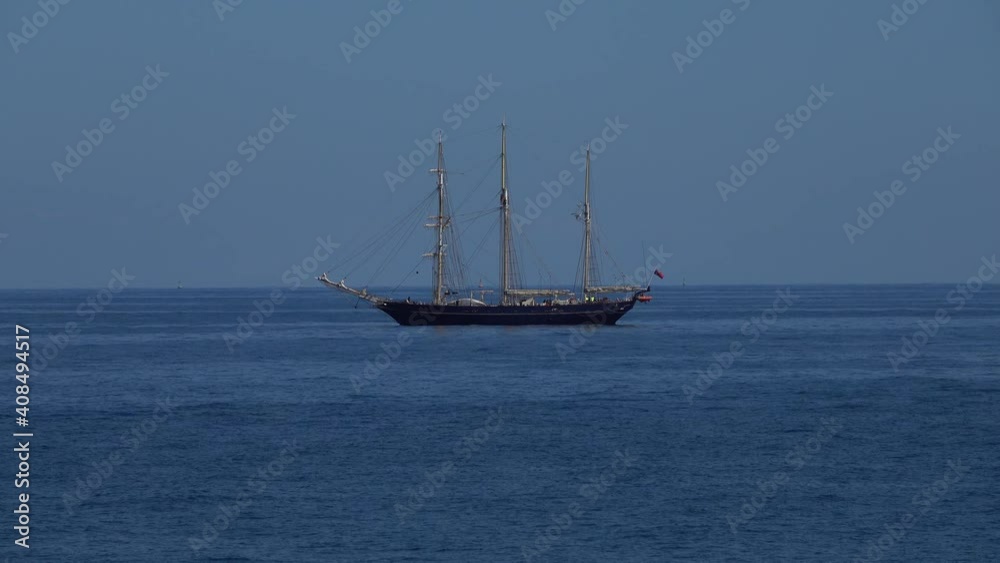 A schooner barque sailing vessel with three masts at anchor in calm seas of the coast of Australia. A schooner barque sailing vessel with three masts at anchor in calm seas of the coast of Australia.
