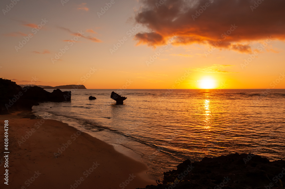 Vibrant warm sunset with orange and yellow colors, and some rocks typical from Okinawa seashore. Iriomote Island.