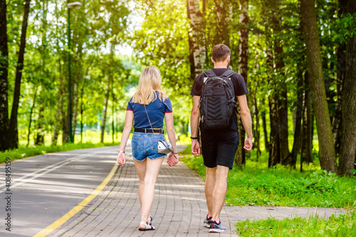 Fototapeta Naklejka Na Ścianę i Meble -  A guy and a girl walk along the path in the city Park

