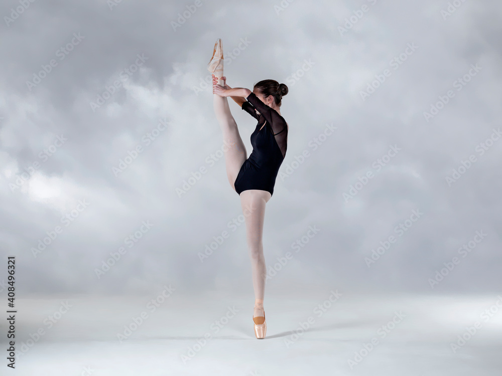 Fototapeta premium Dancer in vertical split on a cloud background 