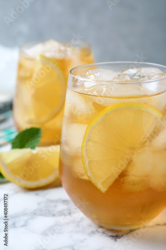 Delicious iced tea on white marble table, closeup