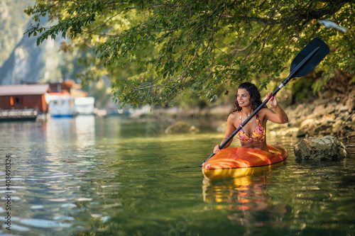 Smiling woman kayaking in water