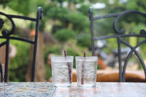 2 glasses of cold water on the table in cafe garden background