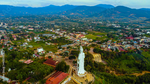 Aerial view of Linh An Pagoda, DaLat city, Lam Dong province, Vietnam. A statue is white and 71 meters high. Selective focus. Thac Voi waterfall, forest and city scene in background.