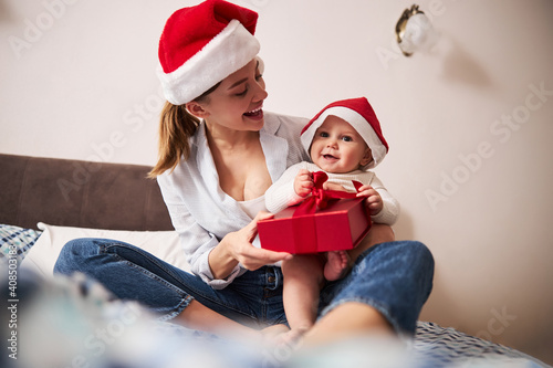 Cute woman laughing while playing with baby