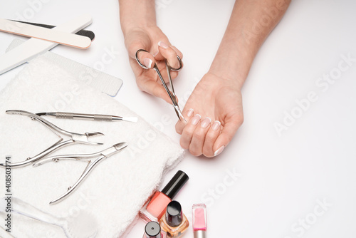top view of manicure tools set for nail care over light background - brush, scissors, nail polish, file and tweezers