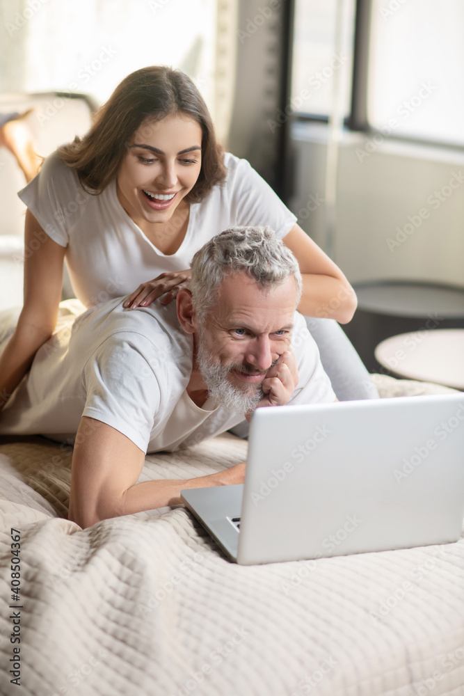 Man working on laptop at home and woman