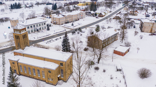 Akniste, Jekabpils, Latvia, Baltics. Beautiful panoramic aerial view photo from flying drone to Akniste Catholic Church In white snow on a snowy winter day. Architectural Heritage. (series) photo