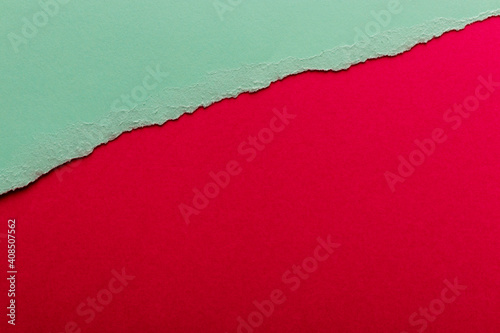 Ripped paper, space for copy. Torn green paper on red background.