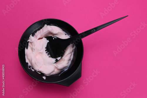 hair dye with a brush in a bowl on a pink background photo