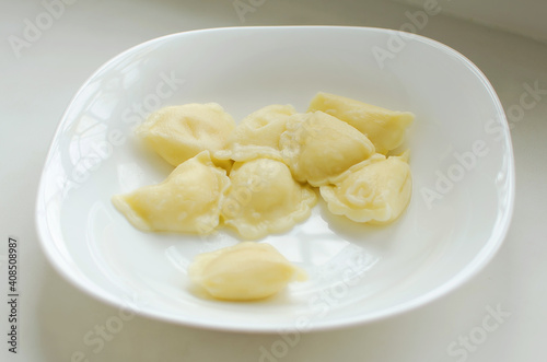 Homemade meat dumplings - russian pelmeni. Dumplings, filled with potato, ravioli. Dumplings with filling. Close-up.