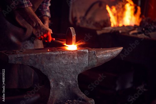Slika na platnu Close Up Of Male Blacksmith Hammering Metalwork On Anvil With Sparks