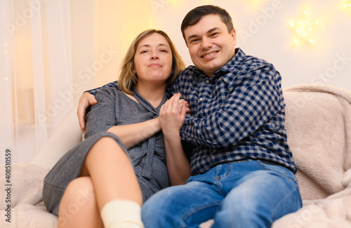 portrait of adult couple sitting on a sofa at home