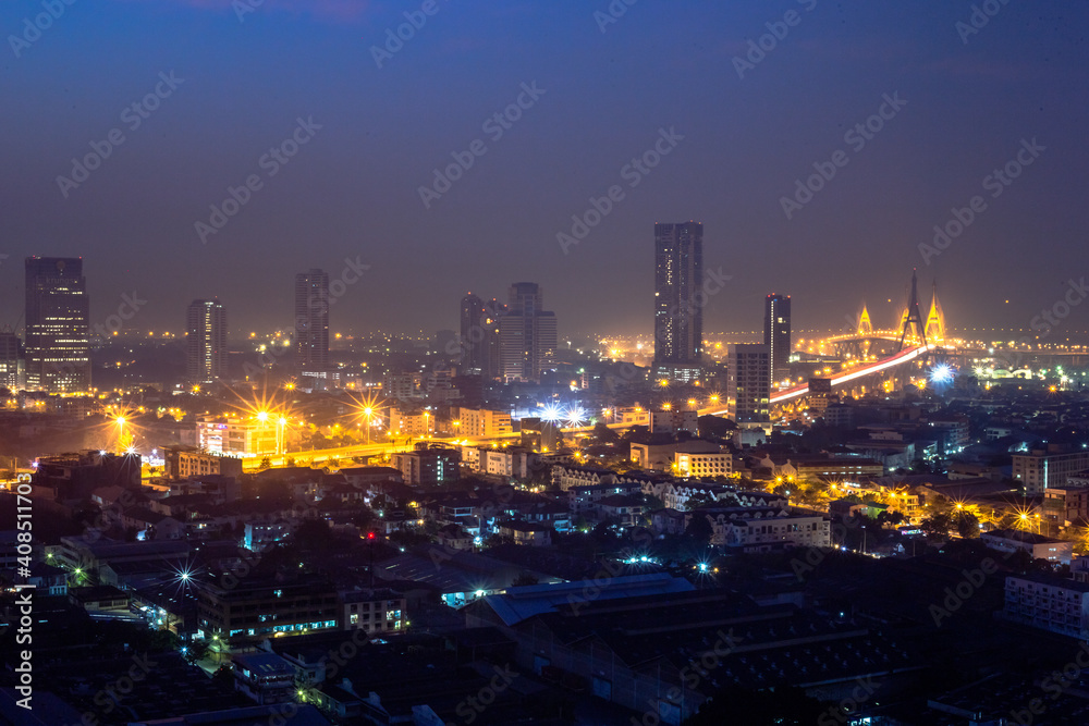 Fototapeta premium The high angle background of the city view with the secret light of the evening, blurring of night lights, showing the distribution of condominiums, dense homes in the capital community