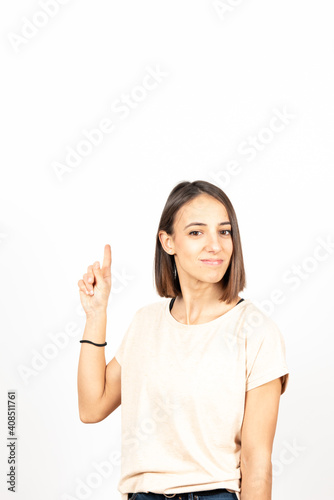 Pretty hispanic girl pointing up to white copy space
