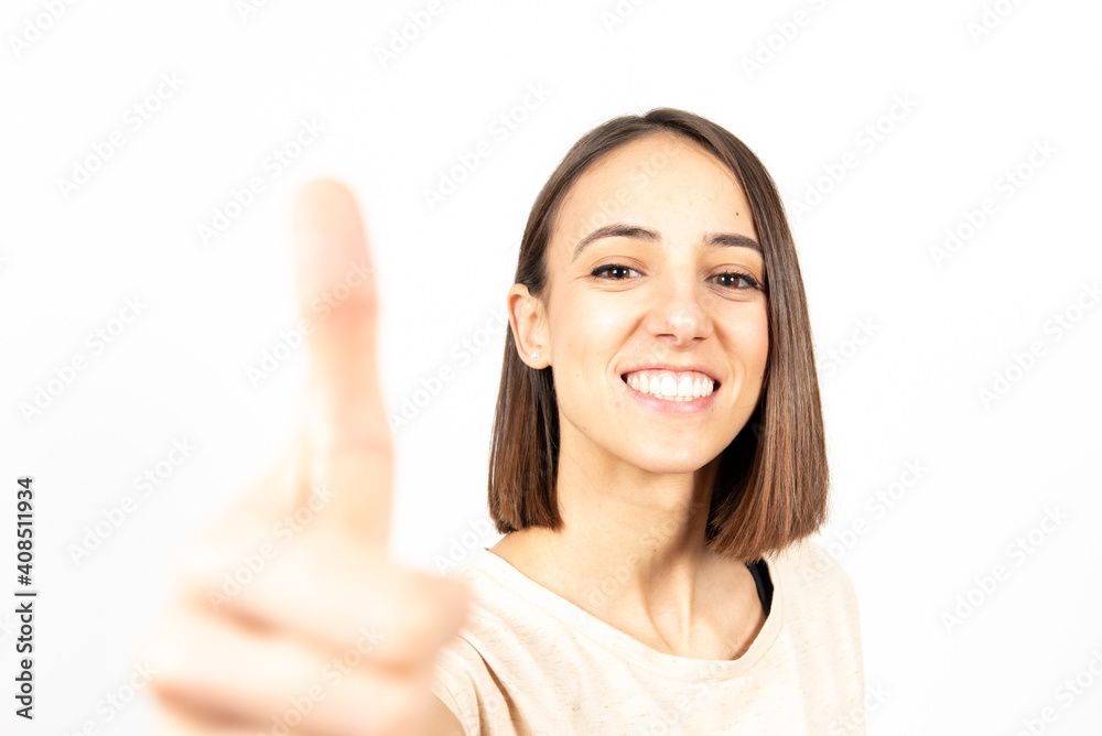 A smiling pretty latin woman with the thumb up isolated on white background. A smiling pretty latin woman with the thumb up isolated on white background.