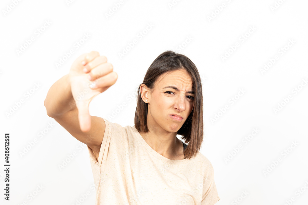A disgusted girl with nasty face showing the thumb down. A disgusted girl with nasty face showing the thumb down.