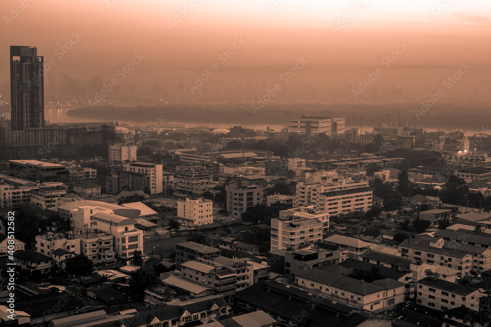 Fototapeta premium The high angle background of the city view with the secret light of the evening, blurring of night lights, showing the distribution of condominiums, dense homes in the capital community