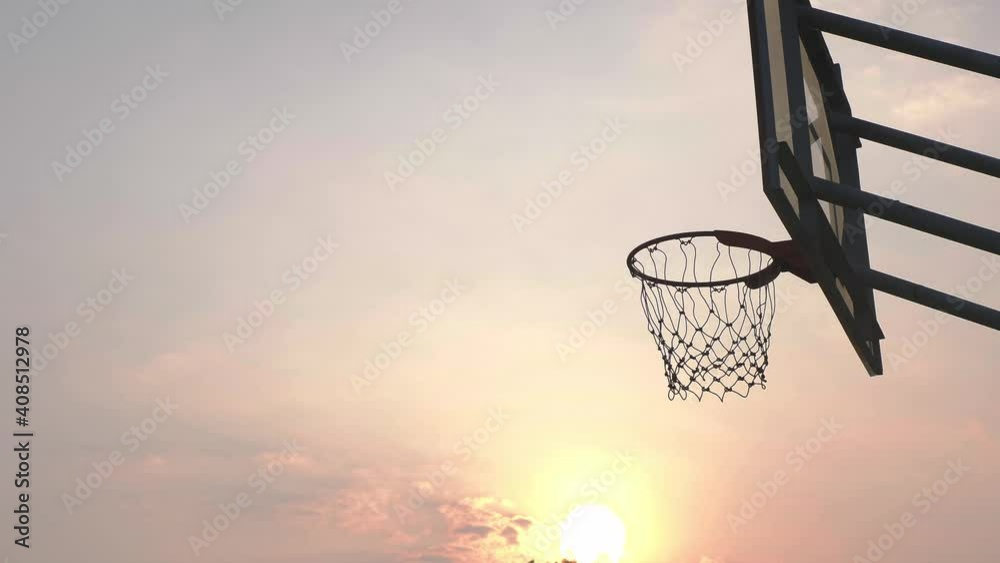 Basketball going through the basket at a sports arena
Basketball going through the basket at a sports arena