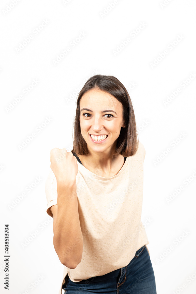 A happy latin woman celebrating a victory looking straight to the camera. A happy latin woman celebrating a victory looking straight to the camera.