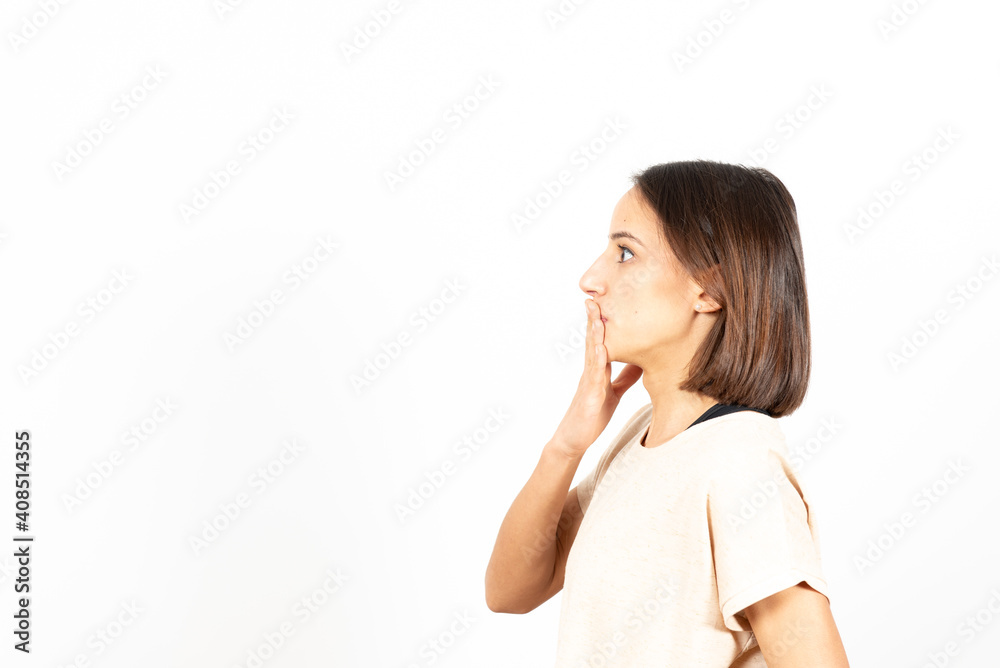 Side view of a latin woman covering her mouth and regreting something she has said. Side view of a latin woman covering her mouth and regreting something she has said.
