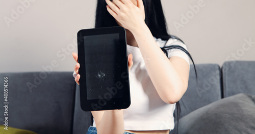 girl shows a broken tablet.