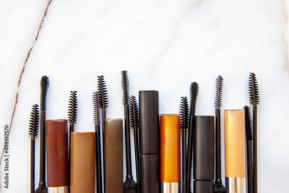 Flat lay of composition of mascara brushes, mascara for eyelash and eyebrow on white marble table. Flat lay of composition of mascara brushes, mascara for eyelash and eyebrow on white marble table.
