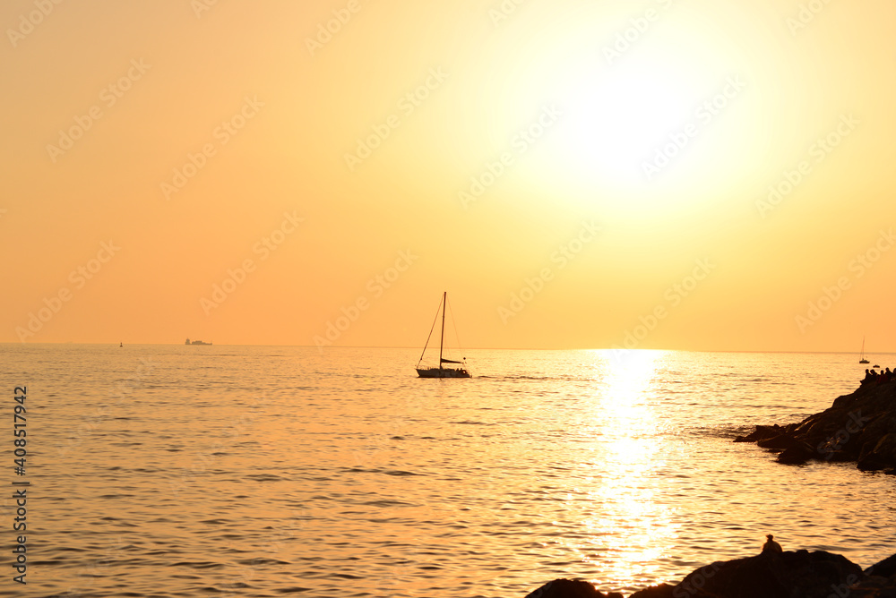 Boat at sea while sun sets