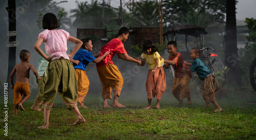 Group of Asian children in traditional costumes playing outdoor activities. local traditional game in Thai culture concept. 