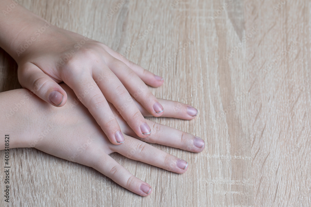 Naklejka premium Children's hands with dirty nails on the table.