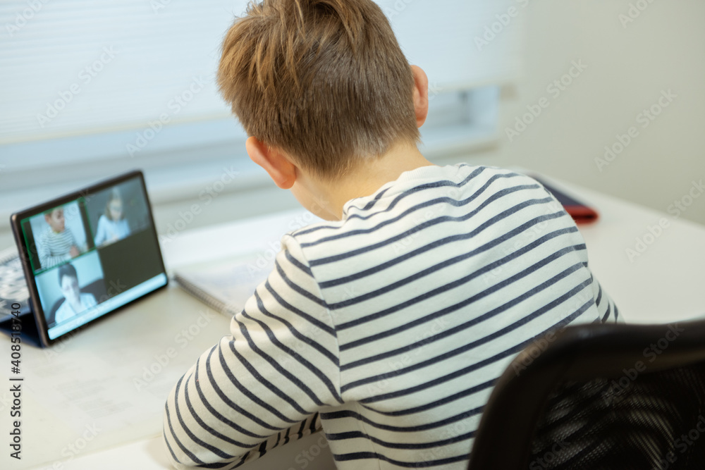 Teenager schoolboy at virtual lesson at home using tablet during homeschooling at pandemic quarantine Teenager schoolboy at virtual lesson at home using tablet during homeschooling at pandemic quarantine