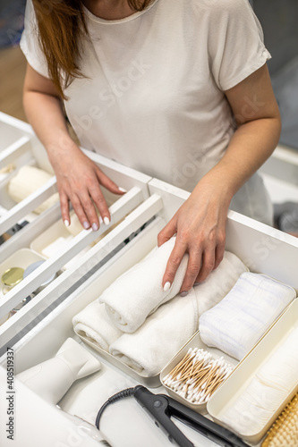 Konstfotografi Young woman organizing bathroom storage, displaying beauty cosmetic creams and t