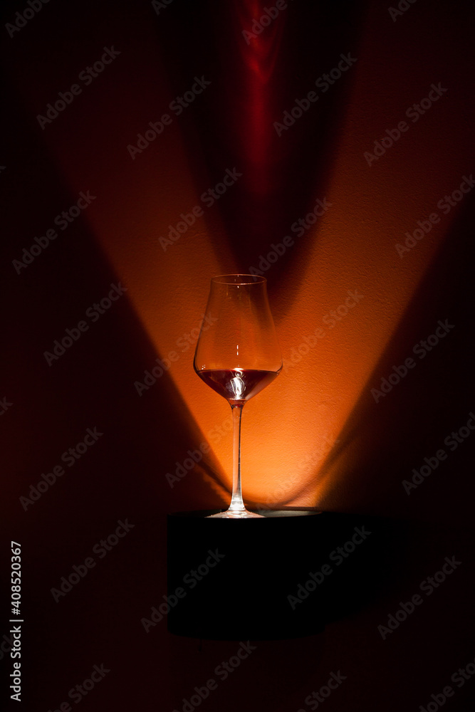 wine glass illuminated by a lamp, light in the form of the letter V wine glass illuminated by a lamp, light in the form of the letter V