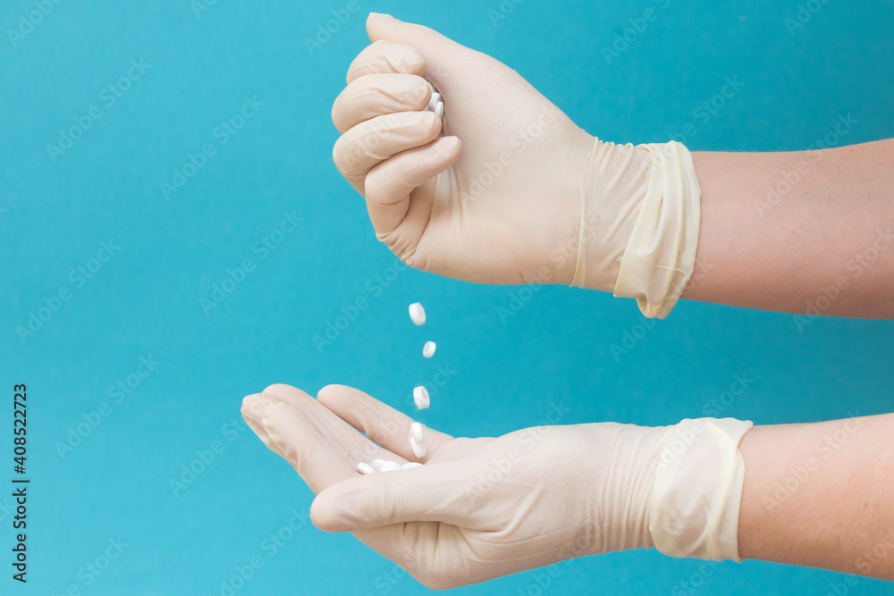 the pills are poured from hand into palm. Hands in medical gloves. Concept - treatment, medicines. horizontal photo. Close-up. the pills are poured from hand into palm. Hands in medical gloves. Concept - treatment, medicines. horizontal photo. Close-up.