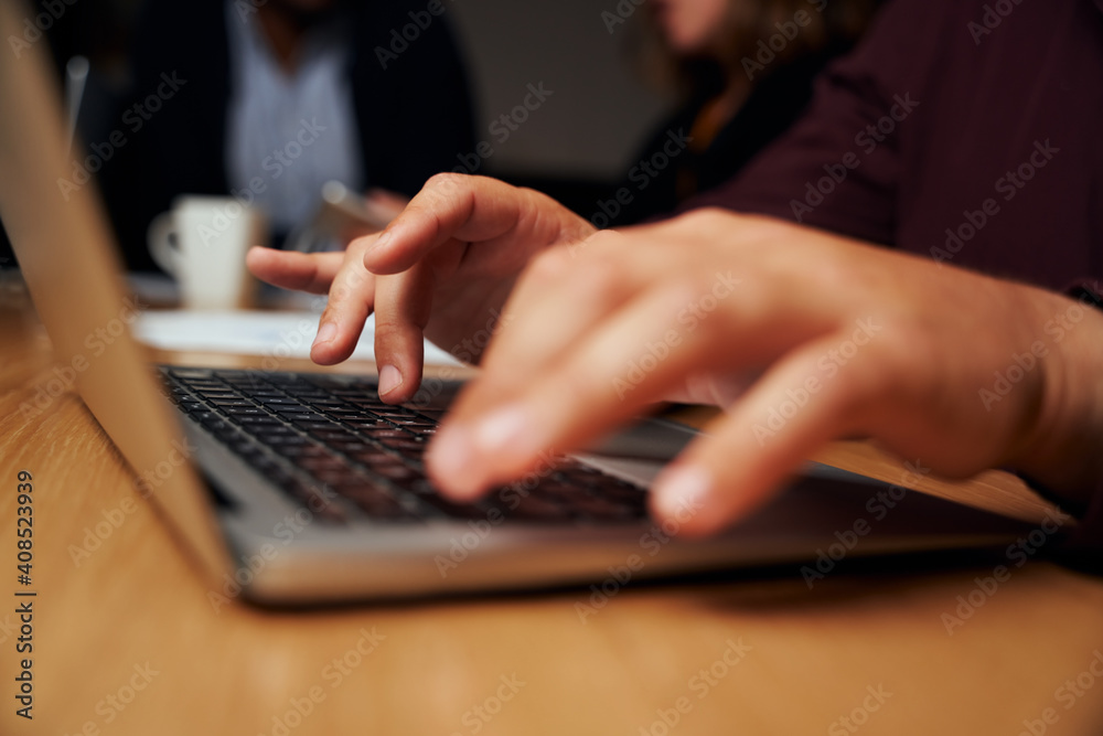 Close-up of a businessman's hand typing on laptop over the office desk Close-up of a businessman's hand typing on laptop over the office desk