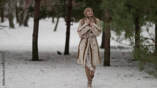 Wallpaper Mural A fashionable blonde in a beautiful fur coat and a beige hat walks and poses against the background of a cold winter forest. The model is located on the street on a snowy background. Torontodigital.ca