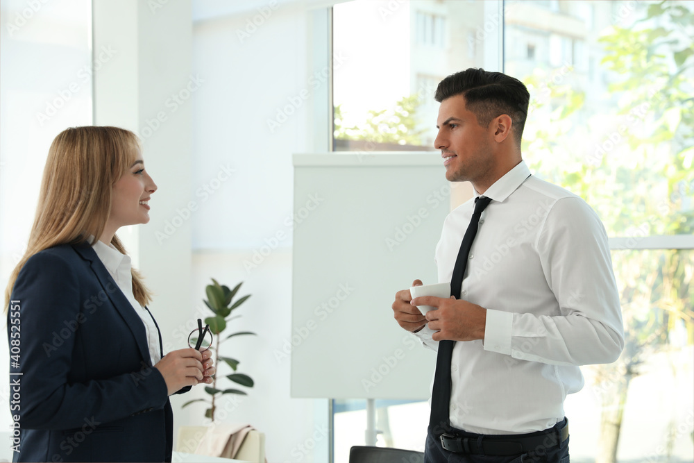 Office employees talking at workplace during break Office employees talking at workplace during break