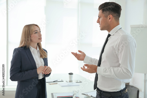 Office employees talking at workplace during break