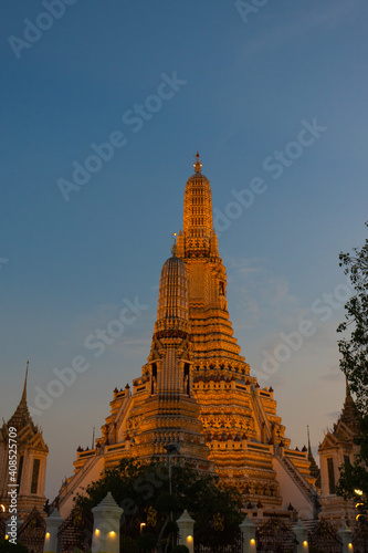 Illuminated Wat Arun Temple in sunset. Buddhist temple in Bangkok, Thailand. Vertical orientation  © Yevheniia Kudrova