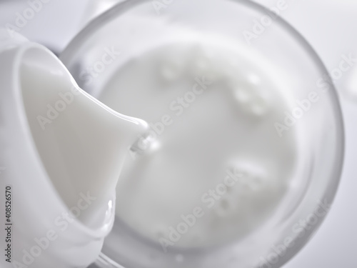 Top view, Poured milk into clear glass (Focus on milk at mouth of bottle) with copy space, Use as background or wallpaper.