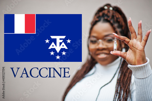 African woman show vaccine for French Southern and Antarctic Lands. Vaccination of Africa countries concept. photo