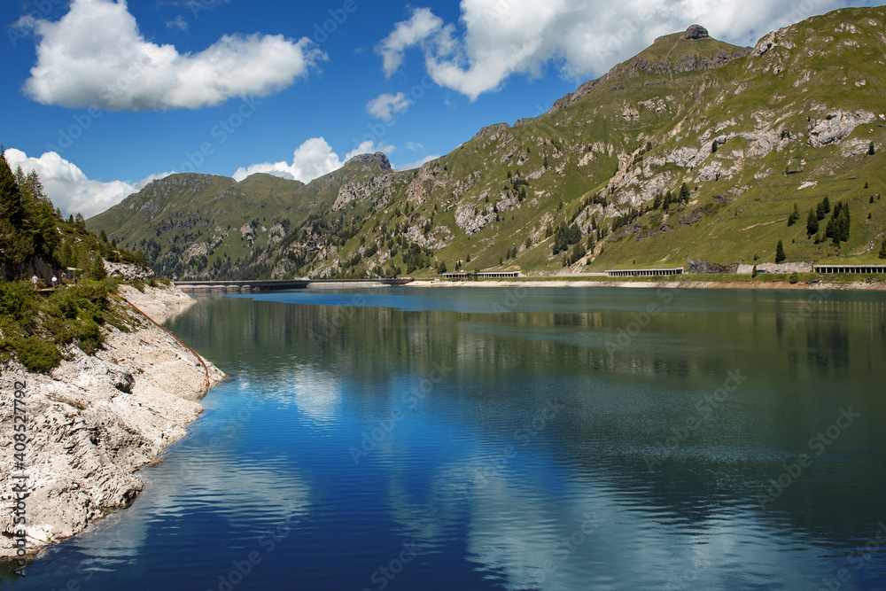 Breathtaking panorama of the Fedaia pass dam in the Dolomites. Border between Trentino Alto Adige and Veneto