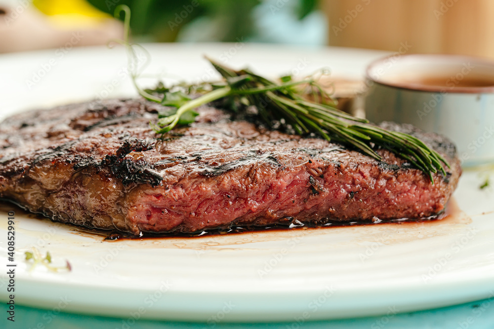 Closeup on roasted beef medium rare steak with a rosemary