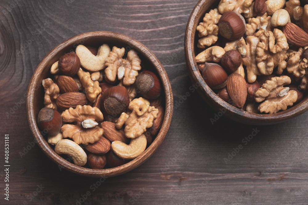 Bowls with mixed nuts on wooden table. Healthy organic food. Close up, top view Bowls with mixed nuts on wooden table. Healthy organic food. Close up, top view