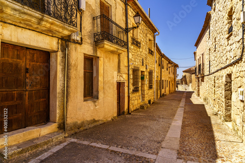 Medieval village with stone houses, cobblestone streets, old doors and windows, arches and walls. Maderuelo Segovia Spain. 
