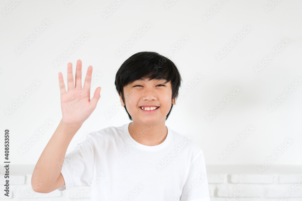 Portrait Asian boy waving hand for greeting on white background Portrait Asian boy waving hand for greeting on white background