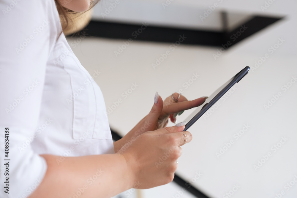 Brunette Caucasian woman in white blouse and brown skirt working via internet using tablet. Work from home concept. Space for text Brunette Caucasian woman in white blouse and brown skirt working via internet using tablet. Work from home concept. Space for text