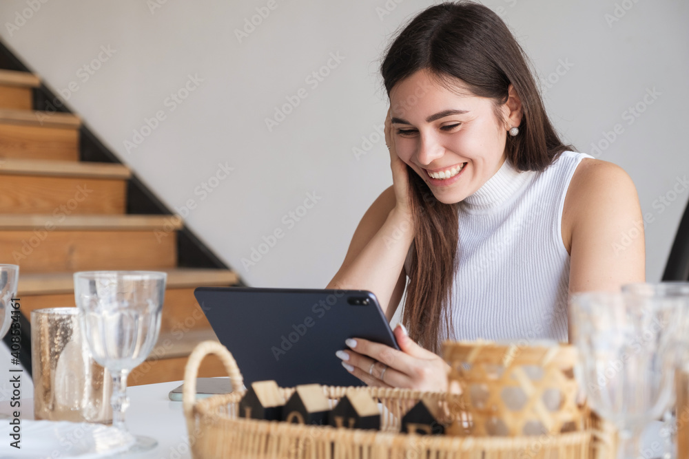 Brunette Caucasian woman in white blouse and black skirt working via internet using tablet. Work from home concept. Space for text Brunette Caucasian woman in white blouse and black skirt working via internet using tablet. Work from home concept. Space for text