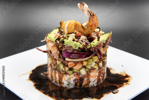 Cylindrical tower of various shellfish and seafood delicately constructed topped with fried shrimp.
 photo